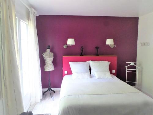 a bedroom with a large bed with a red wall at La Folie in Breuil-Barret