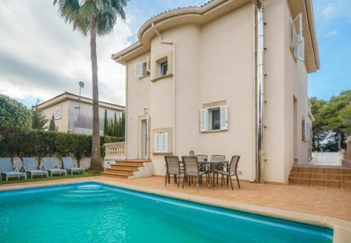 een huis met een zwembad en een tafel en stoelen bij Playas de Mallorca in Muro