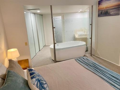a bedroom with a bed and a bath tub and a bath tub at Watermark 105 in Townsville