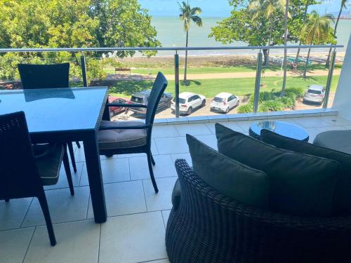 a balcony with a table and chairs and a view of the ocean at Watermark 105 in Townsville