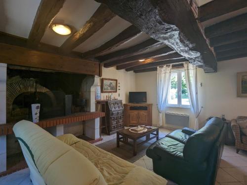 a living room with a couch and a fireplace at Gîte paisible près de Valençay et Zoo de Beauval - FR-1-591-624 in Val-Fouzon
