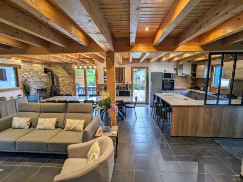 Il comprend un grand salon avec des canapés et une cuisine. dans l'établissement Chalet cosy avec sauna et spa dans le Massif des Vosges - FR-1-589-672, à Dommartin-lès-Remiremont