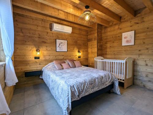 ein Schlafzimmer mit einem Bett und einer Holzwand in der Unterkunft Chalet cosy avec sauna et spa dans le Massif des Vosges - FR-1-589-672 in Dommartin-lès-Remiremont