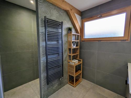 ein Badezimmer mit Dusche mit Fenster und Regalen in der Unterkunft Chalet cosy avec sauna et spa dans le Massif des Vosges - FR-1-589-672 in Dommartin-lès-Remiremont