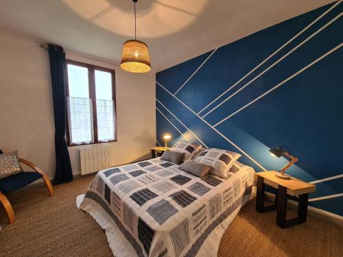 a bedroom with a large bed with a blue wall at Maison individuelle près de la Châtre, jardin privé, jacuzzi - FR-1-591-629 in La Berthenoux
