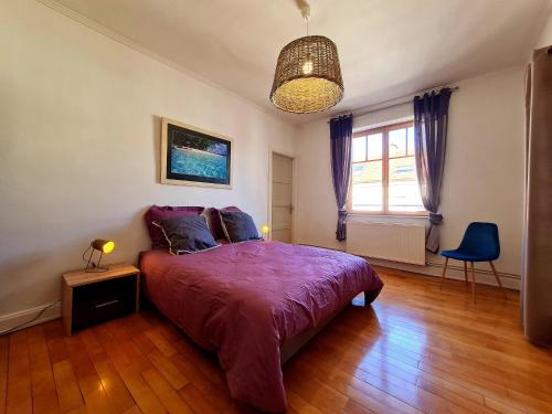 a bedroom with a purple bed and a window at Bel appart au centre avec terrasse et parking - FR-1-589-674 in Gérardmer