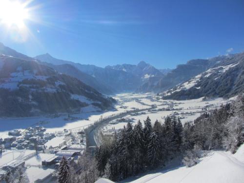 a view of a valley in the mountains with snow at Neurauthof in Zellberg
