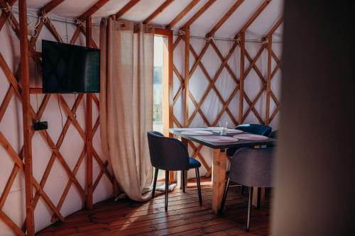 a room with a table and chairs in a yurt at Zatoka Bielika Glamping in Sielsko