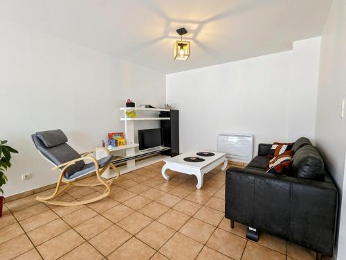 un salon avec un canapé noir et une table dans l'établissement Gîte rénové avec parking à proximité de Saint-Dié-des-Vosges - FR-1-589-675, à Saint-Michel-sur-Meurthe