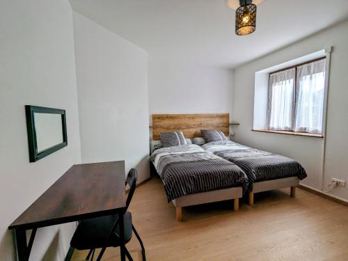 a bedroom with a bed and a desk in it at Gîte rénové avec parking à proximité de Saint-Dié-des-Vosges - FR-1-589-675 in Saint-Michel-sur-Meurthe