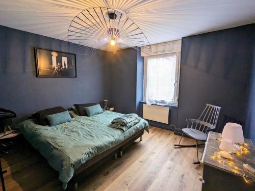 a bedroom with a large bed and a chandelier at Appartement rénové avec jardin, parking et WiFi à Gérardmer - FR-1-589-678 in Gérardmer
