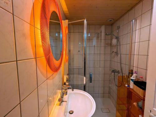 a bathroom with a sink and a mirror and a shower at Appartement rénové avec jardin, parking et WiFi à Gérardmer - FR-1-589-678 in Gérardmer