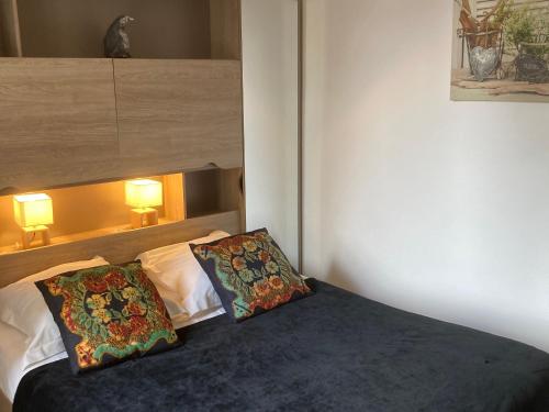 a bedroom with a bed with two pillows on it at Charmant T2 près des Thermes de Nancy avec accueil chaleureux et tout inclus - FR-1-584-339 in Nancy