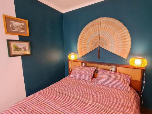 - une chambre avec un lit et un ventilateur mural dans l'établissement Bel appartement 1930 lumineux à Nancy - FR-1-584-337, à Nancy