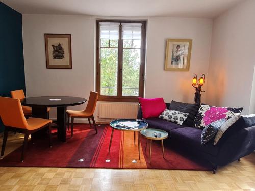 un salon avec un canapé et une table dans l'établissement Bel appartement 1930 lumineux à Nancy - FR-1-584-337, à Nancy