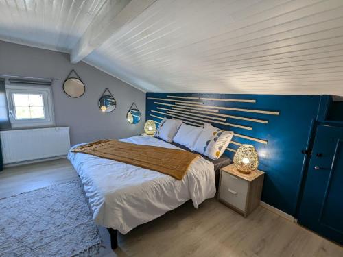 ein Schlafzimmer mit einem großen Bett mit einer blauen Wand in der Unterkunft Maison spacieuse avec jardin privé et WIFI, proche Épinal - FR-1-589-681 in Dinozé