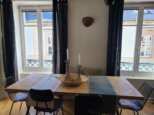 une table de salle à manger avec des chaises et une grande fenêtre dans l'établissement Appartement confortable 4 pers à Épinal avec parking privatif - FR-1-589-682, à Épinal