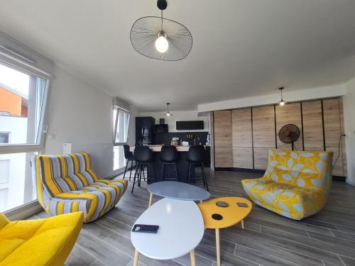 un salon avec deux chaises et une table dans l'établissement Appartement contemporain 3 chambres avec vue sur canal, parking et internet à Nancy - FR-1-584-343, à Nancy