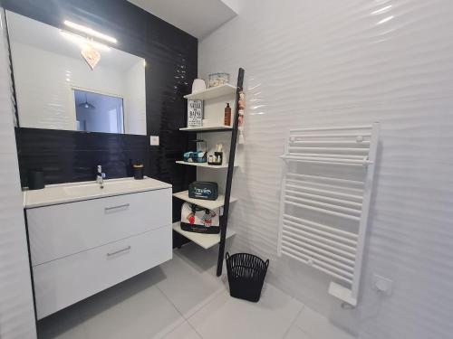 une salle de bain blanche avec un lavabo et un miroir dans l'établissement Appartement contemporain 3 chambres avec vue sur canal, parking et internet à Nancy - FR-1-584-343, à Nancy