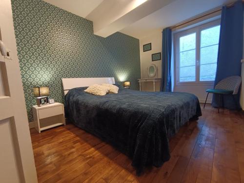 a bedroom with a bed with a black comforter at Maison médiévale en Berry avec cour privative et tout inclus - FR-1-591-643 in Saint-Benoît-du-Sault