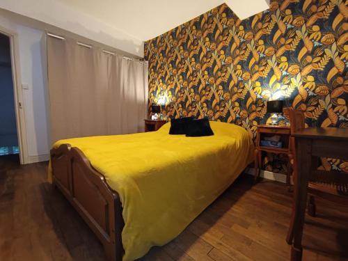 a bedroom with a bed with a yellow bedspread at Maison médiévale en Berry avec cour privative et tout inclus - FR-1-591-643 in Saint-Benoît-du-Sault