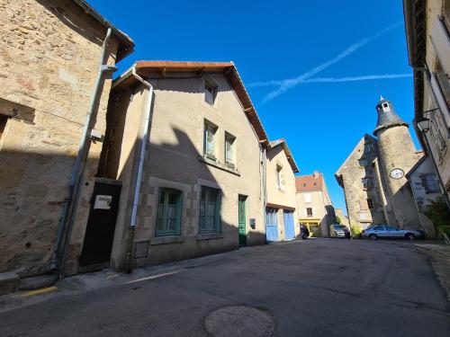 an empty street in an old building with a clock tower at Maison médiévale en Berry avec cour privative et tout inclus - FR-1-591-643 in Saint-Benoît-du-Sault