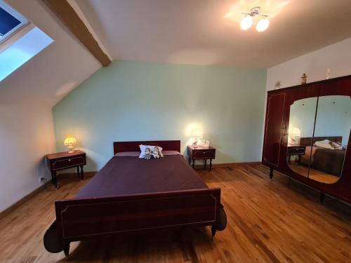 ein Schlafzimmer mit einem großen Bett und einem großen Spiegel in der Unterkunft Maison en Berry avec jardin clos près du lac d'Eguzon - FR-1-591-651 in Orsennes