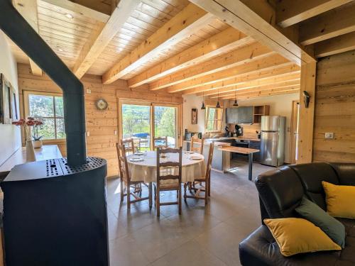 Il comprend une cuisine et un salon avec une table et une cuisinière. dans l'établissement Chalet au cœur des Vosges avec sauna, terrasse et connexion WIFI - FR-1-589-692, à Cornimont