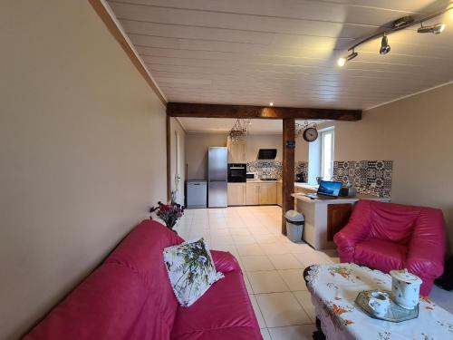 Il comprend un salon avec un canapé violet et une cuisine. dans l'établissement Maison en Berry avec jardin clos près du lac d'Eguzon - FR-1-591-651, à Orsennes