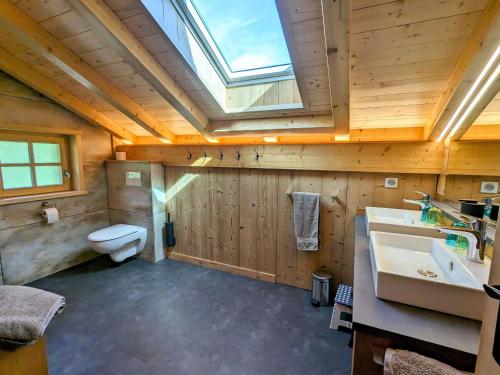 ein Badezimmer mit Toilette und Waschbecken und einem Oberlicht in der Unterkunft Chalet au cœur des Vosges avec sauna, terrasse et connexion WIFI - FR-1-589-692 in Cornimont