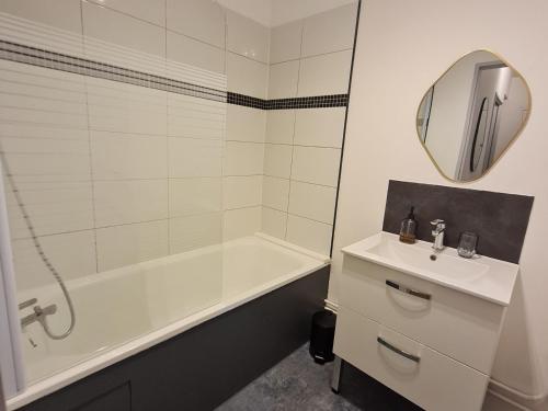 une salle de bain avec une baignoire, un lavabo et un miroir dans l'établissement Appartement central et calme, proche de la Place Stanislas - FR-1-584-350, à Nancy
