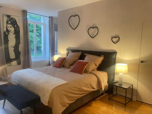 ein Schlafzimmer mit einem Bett mit Herzen an der Wand in der Unterkunft Appartement bourgeois et moderne au cœur d'Épinal, idéal pour découvrir la ville - FR-1-589-691 in Épinal