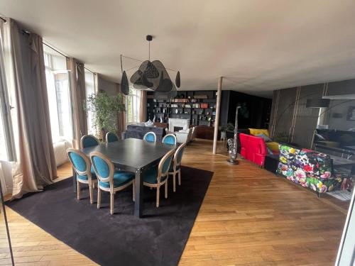 une salle à manger avec une table et des chaises dans l'établissement Appartement bourgeois et moderne au cœur d'Épinal, idéal pour découvrir la ville - FR-1-589-691, à Épinal