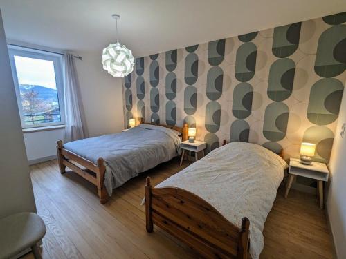 une chambre avec deux lits et deux lampes et une fenêtre dans l'établissement Maison rénovée près des Hautes Vosges, idéale pour activités nature - FR-1-589-696, à Saint-Nabord