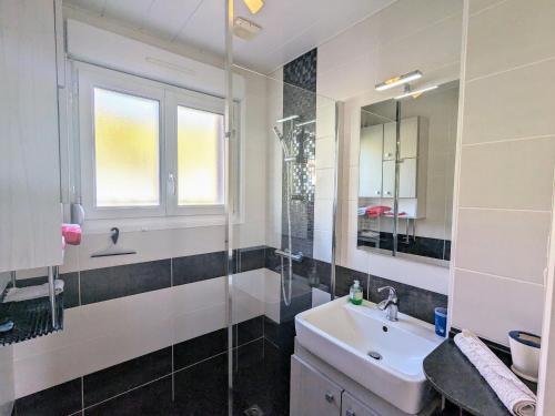 une salle de bain avec un lavabo, une douche et un miroir dans l'établissement Charmant appartement avec terrasse, parking et WiFi à Gérardmer - FR-1-589-752, à Gérardmer