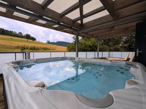 un bain à remous sur une terrasse avec vue dans l'établissement Villa spacieuse avec spa et billard, WiFi, parking privé - FR-1-589-698, à Laveline