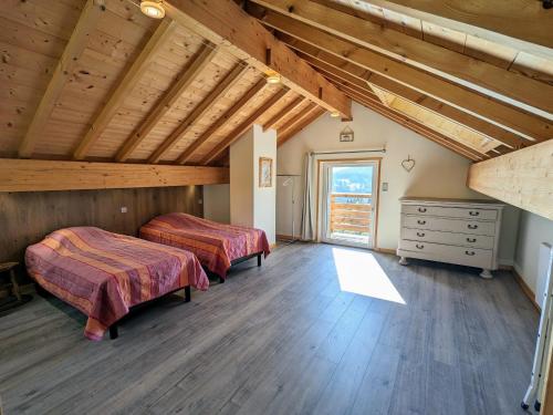 deux lits dans une chambre avec plafonds en bois dans l'établissement Ancienne ferme rénovée à Gérardmer, 3 chambres, confort moderne - FR-1-589-700, à Gérardmer