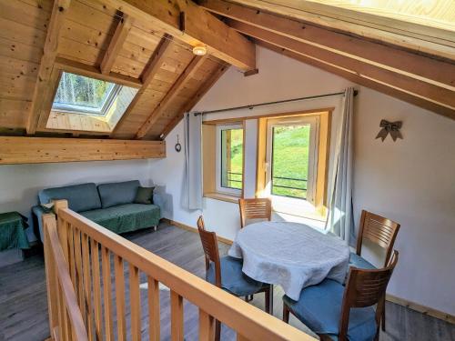 une pièce avec une table, des chaises et un canapé dans l'établissement Ancienne ferme rénovée à Gérardmer, 3 chambres, confort moderne - FR-1-589-700, à Gérardmer