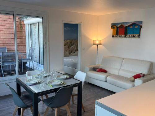 un salon avec une table et un canapé dans l'établissement Appartement 2 pièces avec balcon, parking, internet et animaux acceptés à Cabourg - FR-1-487-375, à Cabourg