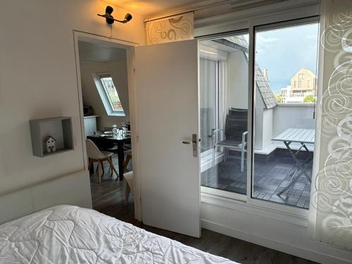 une chambre avec un lit et une vue sur un balcon dans l'établissement Appartement 2 pièces avec balcon, parking, internet et animaux acceptés à Cabourg - FR-1-487-375, à Cabourg