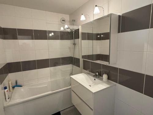 une salle de bain avec un lavabo, une baignoire et un miroir dans l'établissement Appartement 2 pièces avec balcon, parking, internet et animaux acceptés à Cabourg - FR-1-487-375, à Cabourg