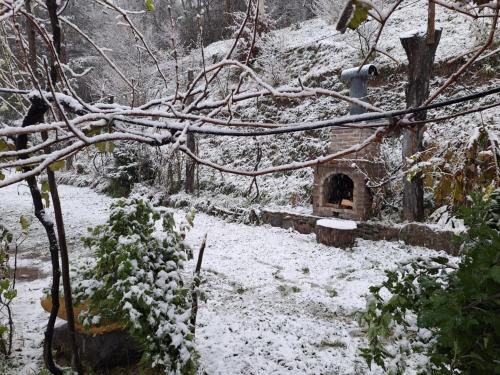a snow covered yard with a house with a bench at Amaghlebakari in Batumi
