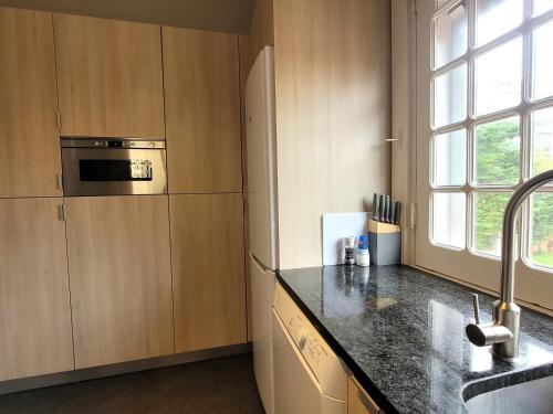una cucina con mobili in legno e un piano di lavoro di A Casa do Escritor a Vila do Conde