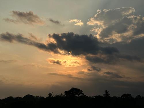 a cloud formation in the sky with the sunset at Brata Cottage Ubud in Ubud