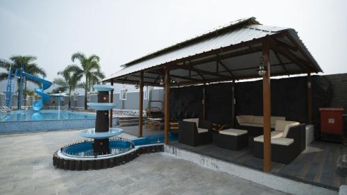 a pavilion with a water fountain next to a pool at Royal Twin Lonavla - 12BHK Luxury Villa with Turf in Lonavala