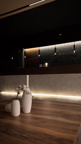 two white vases sitting on top of a wooden floor at Yamato Hostel in Manila