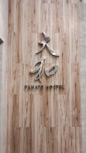 a wooden wall with three spoons on it at Yamato Hostel in Manila