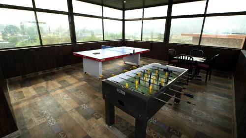 a room with a ping pong table with bottles of wine at Royal Twin Lonavla - 12BHK Luxury Villa with Turf in Lonavala