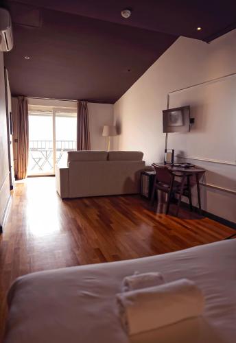 a bedroom with a bed and a couch and a table at Hotel Hita "Nature Experience" for all in Navacerrada