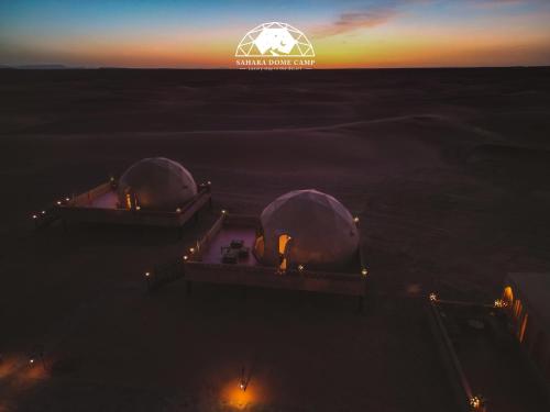 an overhead view of two domes in the ocean at sunset at Sahara Dome Camp in Merzouga